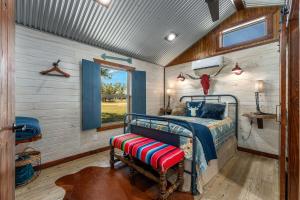a bedroom in a tiny house with a bed and a window at Rockin' R - Morning Star Cabin in Fredericksburg