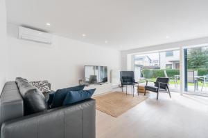 a living room with a couch and a table at Black & White Apartments Rožna dolina in Ljubljana