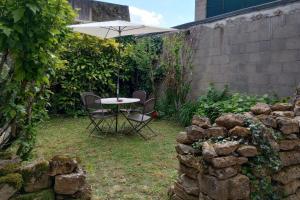 a table and chairs with an umbrella in a garden at Jardin Secret de La Châtre - Centre Ville in La Châtre