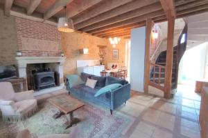 a living room with a blue couch and a fireplace at Jardin Secret de La Châtre - Centre Ville in La Châtre