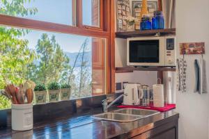 a kitchen with a sink and a microwave and a window at A3- Departamento con Vista Panorámica y Piscina in San Carlos de Bariloche +4 photos