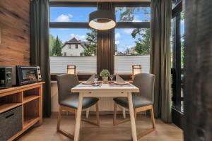a dining room with a table and chairs and a window at HIRSCH Stadt Apartment 1 - Terrasse mit Flussblick - Parkplatz in Bad Harzburg +21 photos