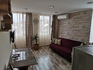 a living room with a couch and a brick wall at Dream Land Batumi in Batumi