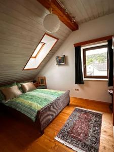 a bedroom with a bed and a window in a attic at Großzügiges Landhaus im Grünen in Oberpiesting +27 photos