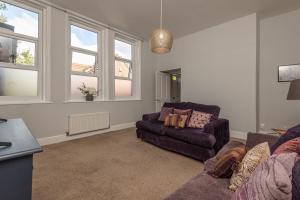 ein Wohnzimmer mit einer Couch und einem Sessel in der Unterkunft Contractors Business Families Relocation Accommodation enjoy Fast WiFi Large Screen Smart TV and SKY Sports in this Spotless Ground Floor apartment in Wakefield