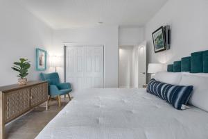 a bedroom with a large bed and two blue chairs at Stonewall Bungalow 3 - Sleeps 4 in Stonewall