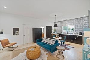 a living room with a blue couch and a kitchen at Stonewall Bungalow 3 - Sleeps 4 in Stonewall