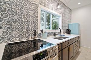a kitchen with a black and white patterned wall at Stonewall Bungalow 3 - Sleeps 4 in Stonewall +29 photos