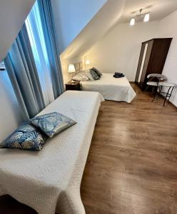 two beds in a room with blue curtains at Rodart Morski in Sztutowo