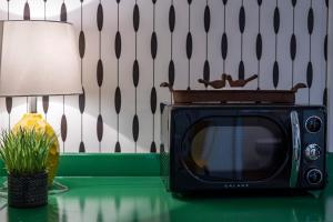 a black microwave sitting on a table next to a lamp at Stonewall Bungalow 4 - Sleeps 3 in Stonewall