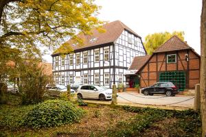 ein Gebäude mit zwei davor geparkt in der Unterkunft Hotel Alter Wolf in Wolfsburg