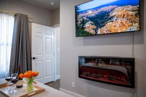 a living room with a tv hanging on the wall at Strawberry Suite - Fire Pit BBQ Grill & more in Fredericksburg