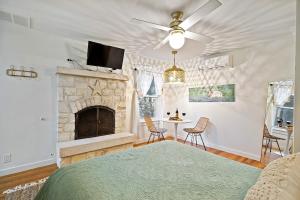 a living room with a fireplace and a bed at Stonewall Bungalows - Sleeps 15 in Stonewall