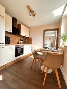 eine Küche mit einem Tisch und Stühlen im Zimmer in der Unterkunft Traum-Ferienwohnungen Georgenthal in Georgenthal