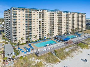 an aerial view of a resort with a pool and beach at 4 Loungers 2 Umbrellas Inlc Peak Season Beachfront in Panama City Beach