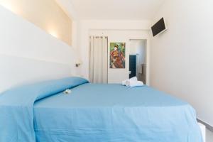a bedroom with a blue bed in a white room at Villa Gioiello CENTRO in Favignana