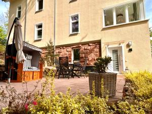 a house with an umbrella and a table and chairs at Traumferienwohnungen Georgenthal in Georgenthal