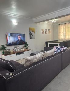 a living room with a couch and a flat screen tv at Amazing home stays in Dar es Salaam