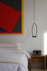 1 dormitorio con 1 cama con una foto y un altavoz en Fragile Hotel en Ciutadella