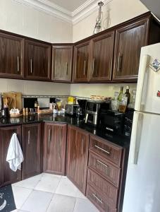 a kitchen with wooden cabinets and black counter tops at Amazing home stays in Dar es Salaam +9 photos