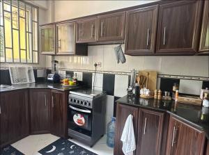 a kitchen with wooden cabinets and a stove top oven at Amazing home stays in Dar es Salaam