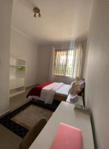 a small room with a bed and a window at Amazing home stays in Dar es Salaam