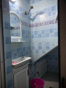 a blue tiled bathroom with a sink and a shower at Blue heart in Chefchaouene