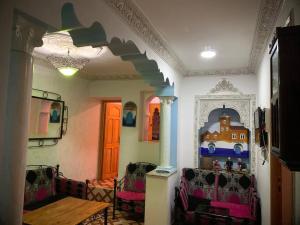 a room with two chairs and a table and a wall at Blue heart in Chefchaouen
