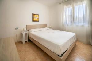 a bedroom with a large bed with white sheets and a window at Villa Danilo - Sicilia Vacanza in Avola