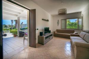a living room with a couch and a television at Villa Danilo - Sicilia Vacanza in Avola