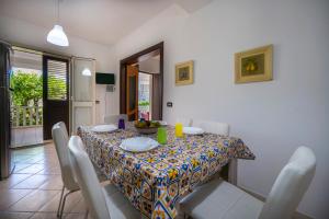 a dining room with a table with chairs and a table cloth at Villa Danilo - Sicilia Vacanza in Avola