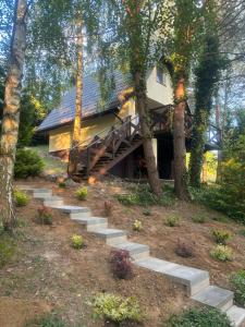 a house with stairs leading up to it at Domek Sosnowe Wzgórze Wiktorowo in Gąsawa