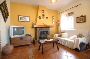 uma sala de estar com um sofá e uma televisão em Cortijo en Frigiliana em Frigiliana