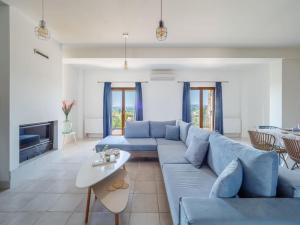 a living room with a blue couch and a table at Villa Althea 1 in Kompítsion