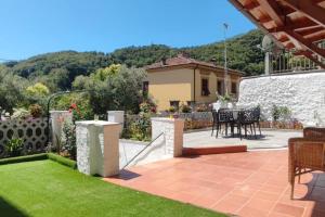 Casa Arcobaleno - giardino e parcheggio gratuito في لا سبيتسيا: فناء مع طاولة وكراسي في ساحة