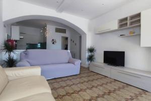 Casa Arcobaleno - giardino e parcheggio gratuito في لا سبيتسيا: غرفة معيشة مع أريكة بيضاء وتلفزيون