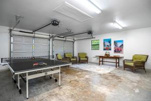 Cette chambre comprend une table de ping-pong et des chaises. dans l'établissement The 309 Retreat - Hot Tub & Fire Pit, à Fredericksburg