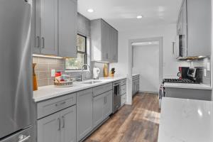 La cuisine est équipée de placards blancs, d'un évier et d'un comptoir. dans l'établissement The 309 Retreat - Hot Tub & Fire Pit, à Fredericksburg