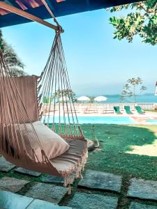 a hammock by the pool at a resort at A vista mais linda de Ubatuba - Acomoda 20 pessoas in Ubatuba