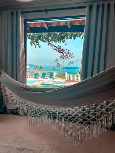 a hammock in a room with a view of the ocean at A vista mais linda de Ubatuba - Acomoda 20 pessoas in Ubatuba