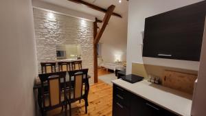 a living room with a flat screen tv and a kitchen at Aven'a pokoje gościnne z basenem in Darłowo