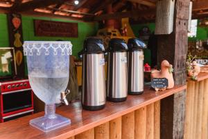 a row of thermos on a shelf with a wine glass at Pousada casa de fadas in Tiradentes