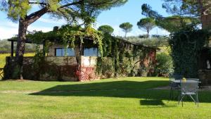 a house covered in ivy with a table and chairs in the grass at Poggio alle Vigne in Torgiano