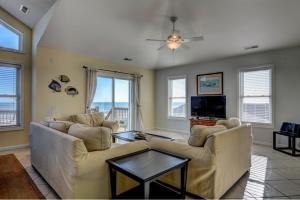 een woonkamer met twee banken en een tv bij Barefoot Bungalow in Surf City