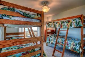 een slaapkamer met 3 stapelbedden in een kamer bij Barefoot Bungalow in Surf City