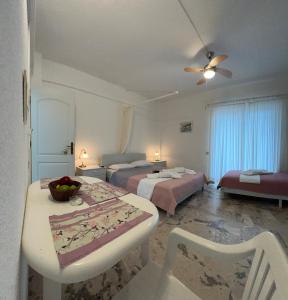a hotel room with two beds and a table and chairs at Villa Katia in Asprovalta