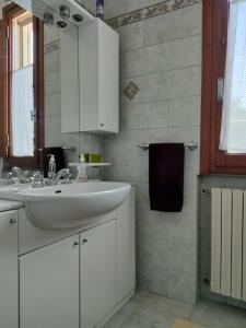 a white bathroom with a sink and a mirror at Podere Gian Battaglia in Fucecchio