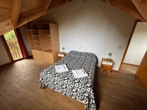 een slaapkamer met een bed met een zwart-wit dekbed bij Casa Mallin Azul in El Bolsón