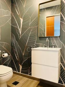 a bathroom with a sink and a leafy wallpaper at Sucre Suites in Buenos Aires +172 photos