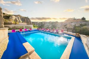 a swimming pool with lounge chairs and a mountain at World Cave House - Hotel & Swimming Pool in Ürgüp